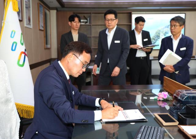 윤희신 태안군수가 취임 첫날 세일즈기획단 설치·운영계획에 1호 결재를 하고 있다사진태안군