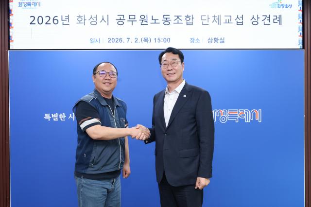 정명근 화성특례시장이 2일 시청 상황실에서 열린 2026년 화성시 공무원노동조합 단체교섭 상견례에서 최태성 전국공무원노동조합 화성특례시지부장과 상생의 노사관계 구축을 다짐하며 악수하고 있다 사진화성시