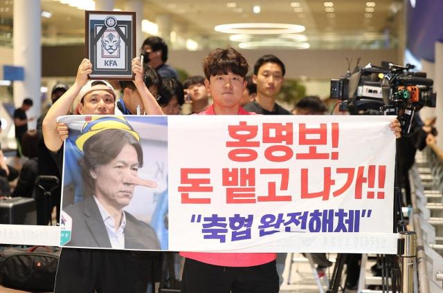 Fans at Incheon International Airport's Terminal 2 hold protest banners on the day Hong Myung-bo returned. Photo: Yonhap News