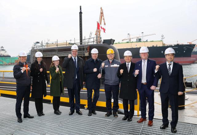 Canada’s Secretary of State for Defence Procurement Stephen Fuhr fifth from left tours the Jang Yeong-sil the lead KSS-III Batch-II submarine proposed for Canada’s CPSP at Hanwha Ocean’s Geoje shipyard alongside Vice Defense Minister Lee Doo-hee seventh from left and Hanwha Ocean CEO Kim Hee-cheul sixth from left Courtesy of Hanwha Ocean