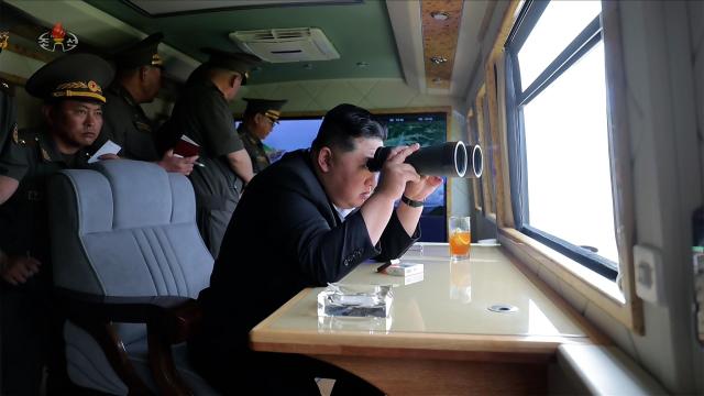 North Korean leader Kim Jong-un watches a major weapons test organized by the countrys defense science institutes through binoculars from an observation post on June 25 2026 in this image released by Korean Central Television KCTV on June 26 2026 Yonhap