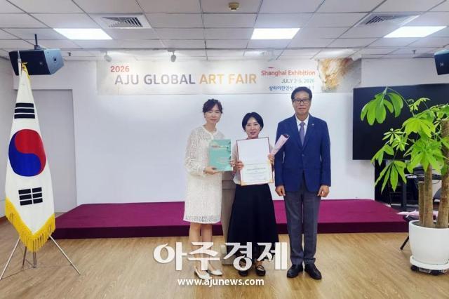 Bang Seon-mi, winner of the Global Grand Prix, is flanked by Reina Lee (left) and Tak Jong-han, president of the Korean Association in Shanghai.