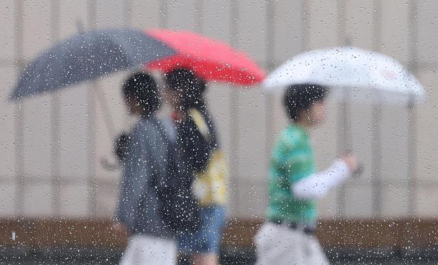 Citizens walk with umbrellas near Gyeongbokgung Palace in Seoul.