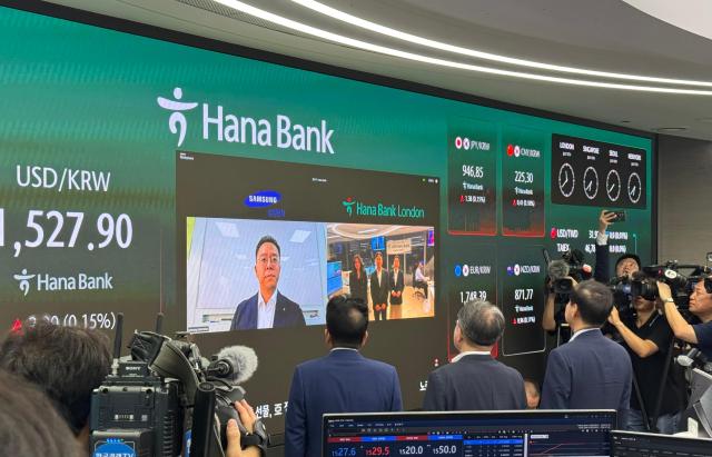 Finance Minister Koo Yun-cheol communicates via video with Hana Bank's London branch during his visit to Hana Bank's dealing room in Seoul on July 6.