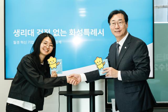 정명근 화성특례시장이 김도진 주해피문데이 대표와 함께 코리요 생리대 시제품을 들고 포즈를 취하고 있다 사진화성시