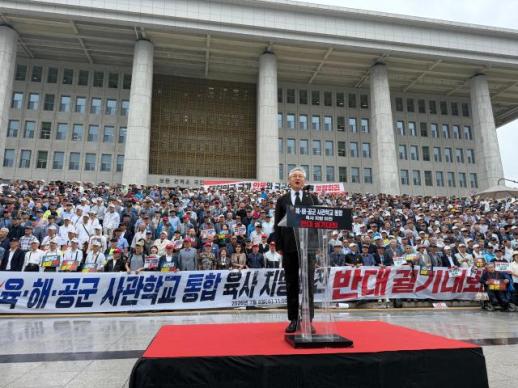 Thousands brave monsoon rain to oppose military academy merger