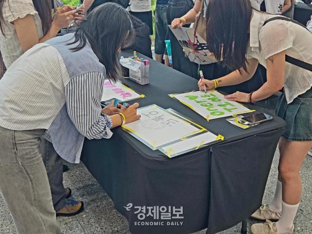MSI를 찾은 방문객들이 응원 문구를 작성하고 있다 사진류청빛 기자