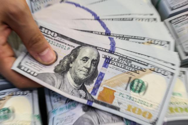 A staff member shows US dollar banknotes at Hana Bank’s Counterfeit Response Center in central Seoul on July 10 2026 AJP Yoo Na-hyun