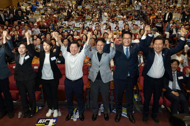 12일 국회 의원회관에서 열린 전국자치분권민주지도자회의KLDC에 더불어민주당 당 대표 후보 주자들과 자치분권회의 상임대표인 박승원 광명시장이 손을 들어 인사하고 있다사진연합뉴스