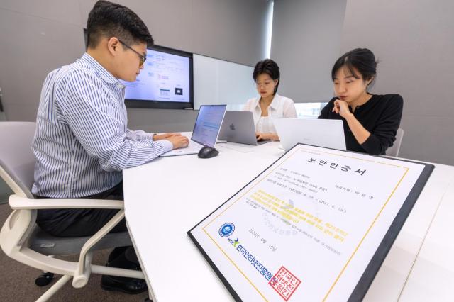 KT 직원이 CSAP 보안인증서와 함께 근무하는 모습 사진KT