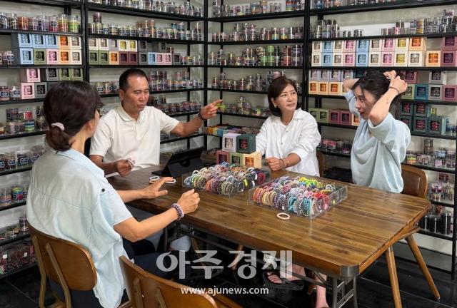 ㈜두지 조현태 회장이 헤어타이 제품을 소개하며 관계자들과 끄네끼의 기술력과 제품 경쟁력에 대해 의견을 나누고 있다사진주두지
