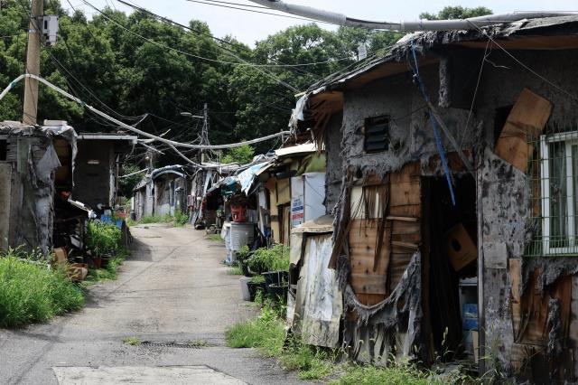 A narrow lane runs between weathered patchwork shanty homes in Guryong Village Seoul South Korea AJP Han Jun-gu
