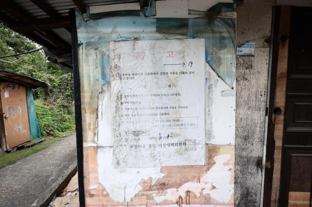  A weathered public notice regarding the village's emergency countermeasures committee is posted on a wall in Guryong Village, Seoul, South Korea. AJP Han Jun-gu