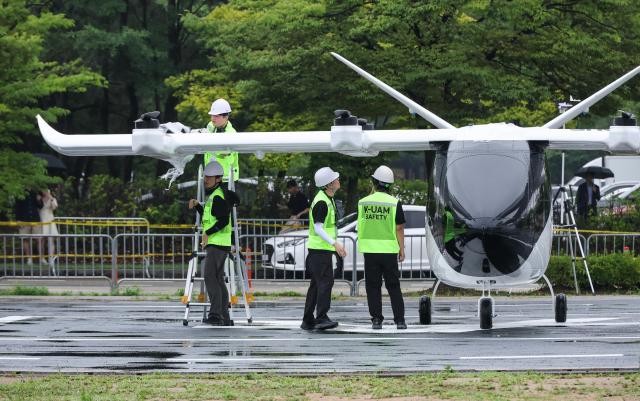 Officials inspect a UAM aircraft during the 2026 Korea Drone  UAM Expo and Urban Air Mobility UAM Flight Showcase at the INU Innovation Center of the University of Incheon in Incheon on July 15 2026 AJP Yoo Na-hyun