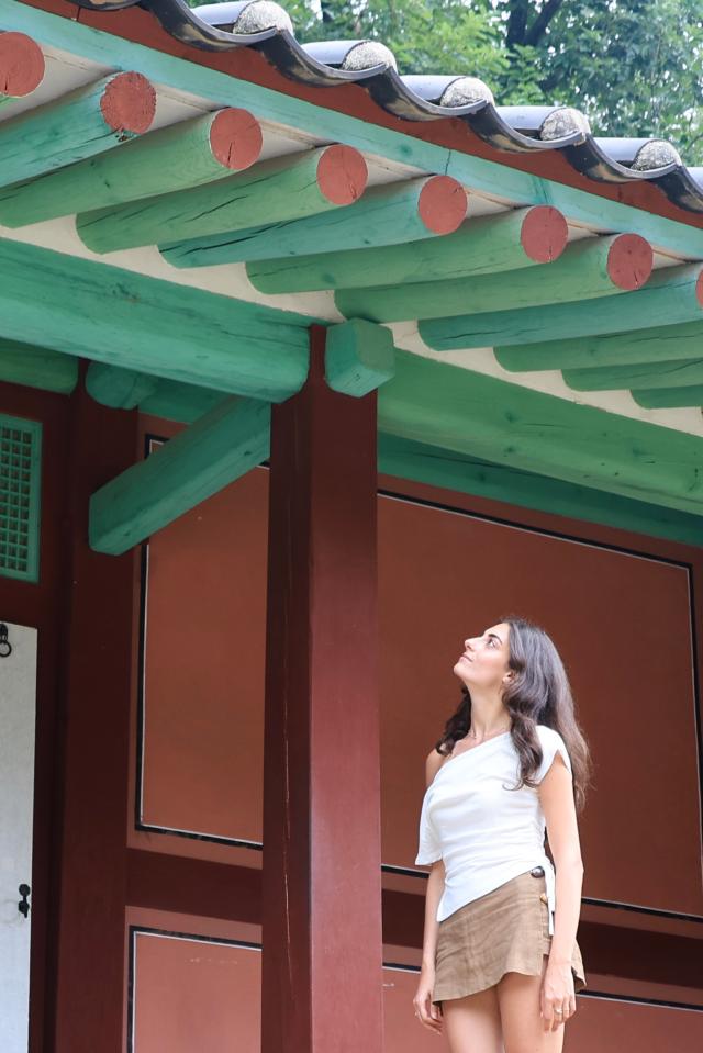 A foreign visitor examines the eaves of a pavilion at Jongmyo Shrine in Seoul July 16 2026 AJP Han Jun-gu