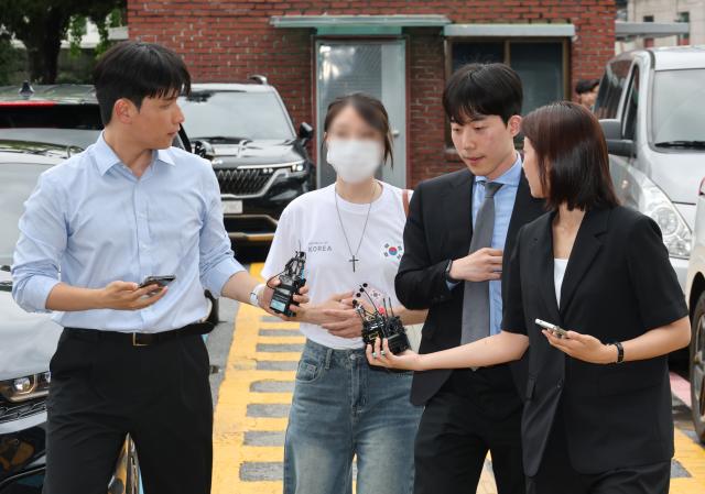 6·3 지방선거 개표소로 사용된 올림픽공원 핸드볼경기장 문 앞에서 체육단체 직원들의 장내 사무실 진입을 막아 업무 방해 혐의를 받는 30대 여성이 10일 서울 송파경찰서에서 조사받기 위해 출석하고 있다 사진연합뉴스