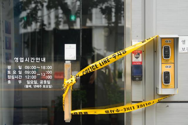 A shuttered building entrance wrapped in polices Do Not Enter tape near the Coupang Warehouse fire in Incheon 20260720 AJP Han Jun-gu