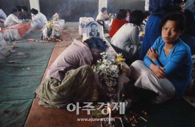 패트릭 쇼벨 기자가 찍은 사진 중 하나 희생자들의 시신을 담은 관 앞에서 유족들이 오열하고 있다 사진광주특별시