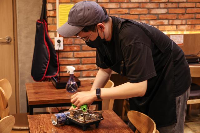 Kim Ji-woo, a borderline intellectual functioning working at the Youth Mungan Nakseongdae branch cleans up tables, July 20, 2026. AJP Yoo Na-hyun