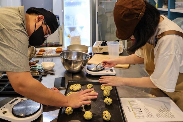 Lee Seung-woo (left) and Ahn Hyo-je bake cookies at the Friends of Star's bakery, July 21, 2026. AJP Yoo Na-hyun