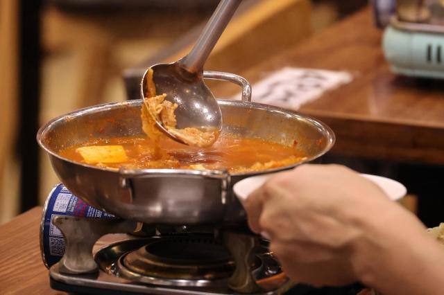 A visitor at the Youth Mungan Nakseongdae branch scoops up kimchi stew July 20 2026 AJP Yoo Na-hyun
