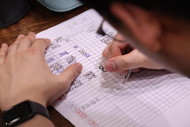 Kim Ji-woo signs his time sheet marking in 300 minutes for his shift July 20 2026 AJP Yoo Na-hyun
