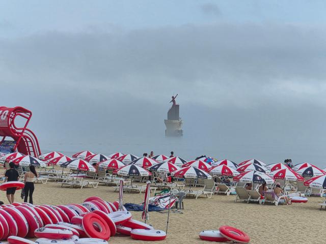 Haeundae beach signature red lighthouse seen at a misty beach in monsoon season in July 2026 AJP Seo Hye Seung
