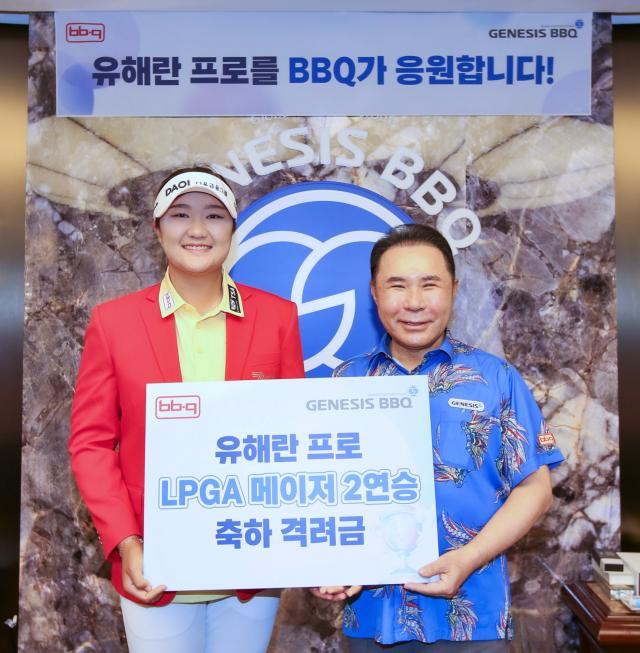 윤홍근 제너시스BBQ 그룹 회장왼쪽과 유해란 프로가 격려금 전달 후 기념촬영을 하고 있다 사진제너시스BBQ그룹