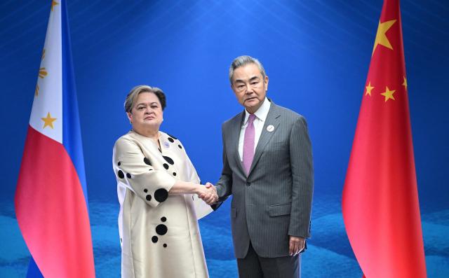 왕이 중국공산당 정치국위원과 테레사 라사로 필리핀 외교장관이 지난 22일 필리핀 마닐라에서 만나 악수를 나누고 있다 사진로이터연합뉴스