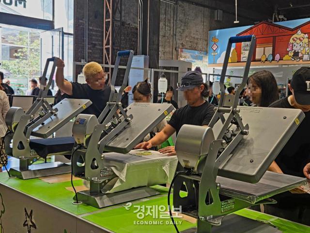 모코코 스트릿 팝업 in 성수 방문객들이 팝업 스토어 직원과 함께 나만의 DIY 티셔츠를 만들고 있다 사진류청빛 기자