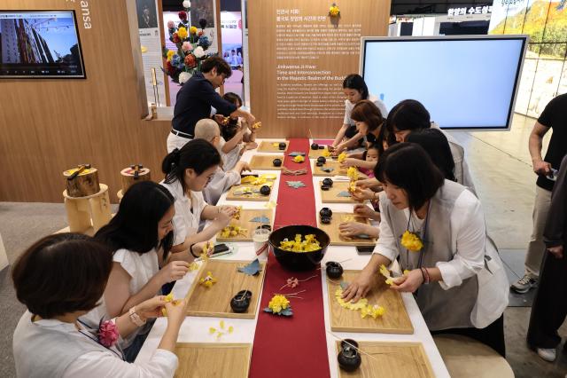 Visitors participate in a traditional paper flower-making program at the Jingwansa Temple booth at the Korea Pavilion the official host country exhibition held alongside the 48th session of the UNESCO World Heritage Committee at BEXCO in Busan on July 24 2026 AJP Yoo Na-hyun