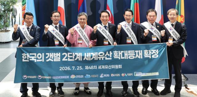 Officials from local governments home to Koreas tidal flats including Korea Heritage Service Administrator Huh Min and South Chungcheong Gov Park Soo-hyun hold a celebratory banner after the second-phase expansion of Getbol Korean Tidal Flats was approved during the 48th session of the UNESCO World Heritage Committee at BEXCO in Busan on July 25 2026 AJP Yoo Na-hyun