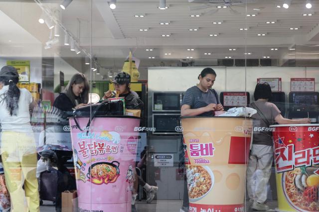 Tourists enjoying cup noodles in a convenient store in Myeongdong July 2026 AJP Yoo Na-hyun