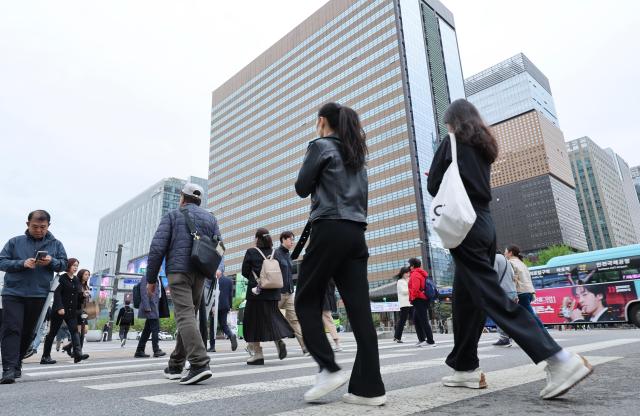 Commuters cross a street in Gwanghwamun central Seoul during the morning rush hour AJP Yoo Na-hyun