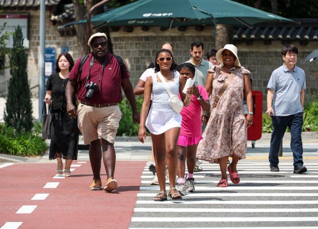 Foreign tourists walk in Jung-gu central Seoul on July 28 2026 as the daytime high reached 32 degrees Celsius AJP Yoo Na-hyun 
