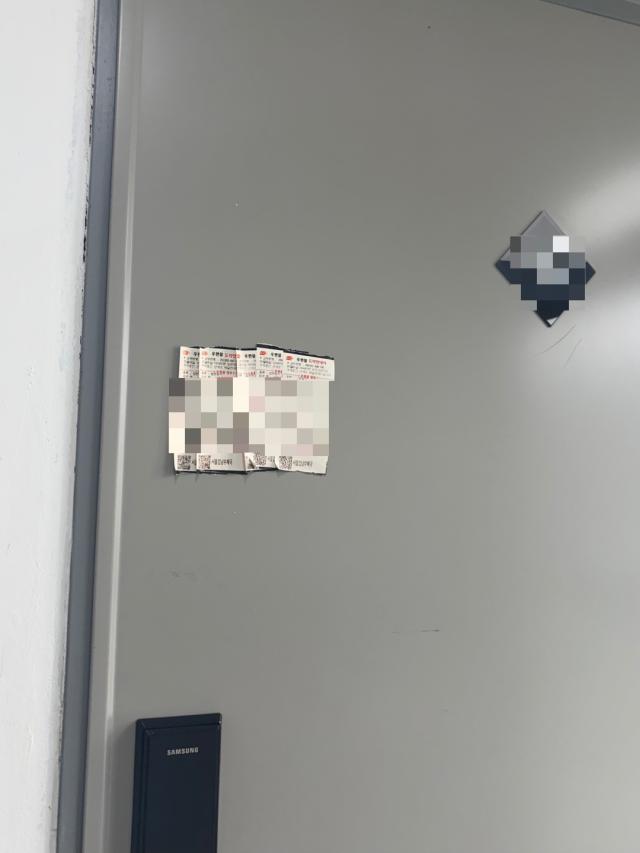 지난 24일 아주경제 탐사보도팀이 부동산 임대 상담을 위해 방문했을 당시 촬영한 협회 오피스텔의 한 현관문 서울고등법원이 보낸 우편물 도착 안내서 여러 장이 수취되지 않은 채 그대로 붙어 있다 사진방효정 기자