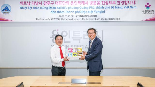 류광열 제1부시장오른쪽이 부이응옥안 꽝푸구 당서기에게 기념품을 전달하고 있다