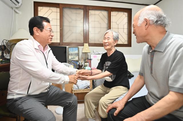 지난 28일 민생 현장 점검에 나선 이현재 하남시장이 덕풍2동의 한 가구를 방문 80대 어르신의 손을 양손으로 꼭 맞잡고 안부인사를 건네고 있다 이날 이현재 시장은 폭염과 침수 위험에 노출된 어르신의 주거 실태를 세심히 살피며 방충망 설치와 후원물품 전달 등 즉각적인 지원을 약속했다 사진하남시