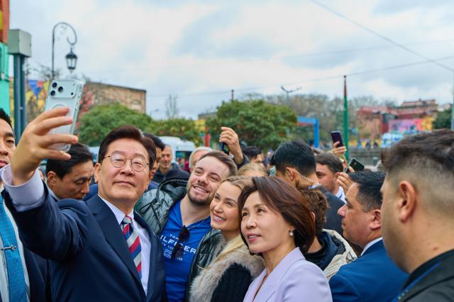 アルゼンチン訪問を終えた李在明大統領と金恵京夫人が1日(現地時間)ブエノスアイレスのボカ地区を訪れ、市民と記念撮影をしている。