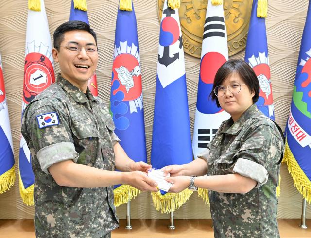 김진숙소령 오른쪽 1함대 정보과장이 헌혈증 기부 운동 담당자 현준혁소령 왼쪽 인사계획과장에게 자신의 헌혈증을 전달하고 있다 김진숙 소령의 기부로 1함대는 목표했던 헌혈증 822장 모으기를 초과 달성했다 사진해군1함대
