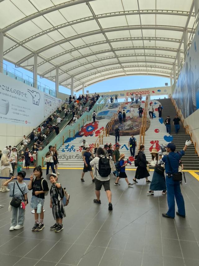 Visitors climb stairs beneath a banner reading Welcome to EXPO2025 at the Osaka-Kansai Expo site in Osaka Japan AJP Joonha Yoo