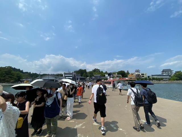 Tourists walk along a pier near a torii gate landmark in Japan Japan received a record number of foreign visitors this year driven in part by a weak yen AJP Joonha Yoo