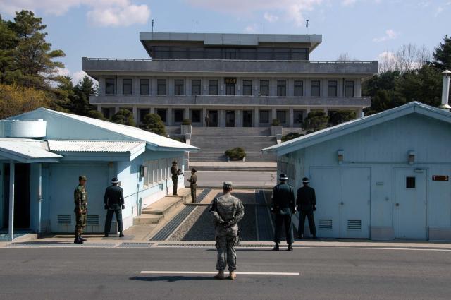 North and South Korean military personnel along with a US soldier stand in the Joint Security Area at Panmunjom on April 3 2007 in a view from the South Korean side toward North Korea Photo by Driedprawns via Wikimedia Commons