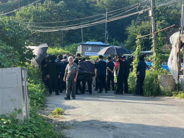 Residents and officials gather on a road inside Guryong Village in southern Seoul on Aug 4 2026 as redevelopment-related work continues nearby AJP Joonha Yoo