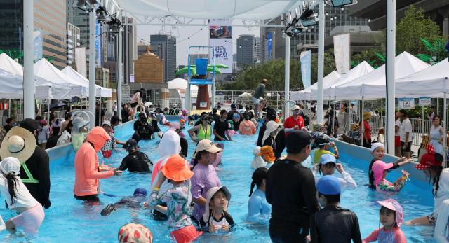 People enjoy the water at the 2026 Seoul Summer Beach swimming pool at Gwanghwamun Square in central Seoul on July 28 2026 Aju Business Daily Yoo Na-hyun
