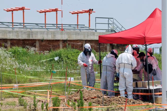 지난 6월 15일 무안국제공항 사고 현장인 콘크리트 둔덕 부근에서 작업자들이 장비를 이용해 흙을 체에 거르고 있다 사진연합뉴스
