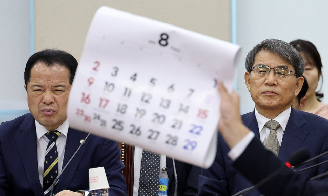 노태악 전 중앙선거관리위원장과 위철환 중앙선거관리위원장 직무대행이 지난 10일 국회에서 열린 제9회 전국동시지방선거 투표용지 부족 사태 등 국민 참정권 침해 진상규명 및 선거관리 개혁을 위한 국정조사 특별위원회 제3차 청문회에서 전용기 더불어민주당 의원이 8월 달력을 들어 보이며 재검표 현장검증 날짜의 조속한 확정을 촉구하는 발언을 듣고 있다 사진연합뉴스