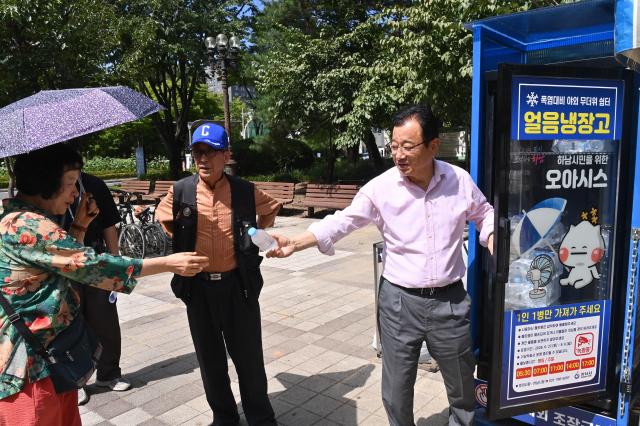 이현재 하남시장이 11일 신장 근린2호공원 야외 무더위쉼터 내 ‘얼음냉장고’ 앞에서 더위를 식히는 시민에게 시원한 생수를 건네며 안부를 묻고 있다 사진하남시