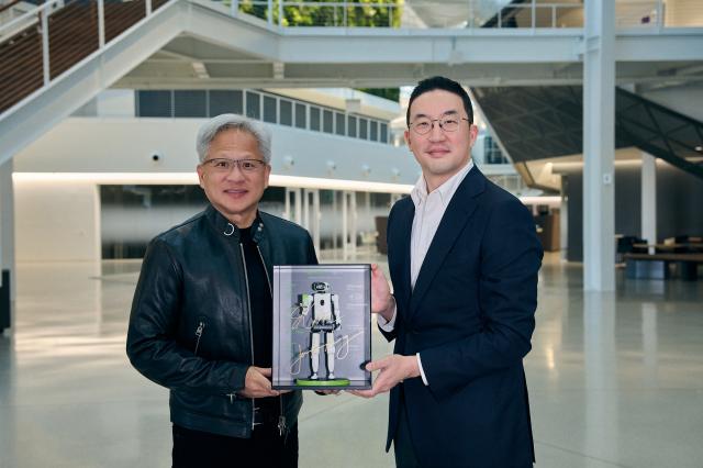 LG Chairman Koo Kwang-mo R and Nvidia CEO Jensen Huang pose with a miniature humanoid robot after signing an MOU in Santa Clara California on Aug 13 Courtesy of LG