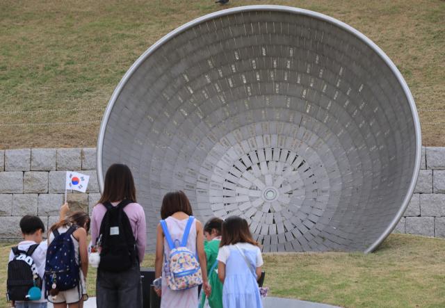 Children bow their heads before a memorial at Seodaemun prison history hall in Seoul August 14 2026 AJP Han Jun-gu